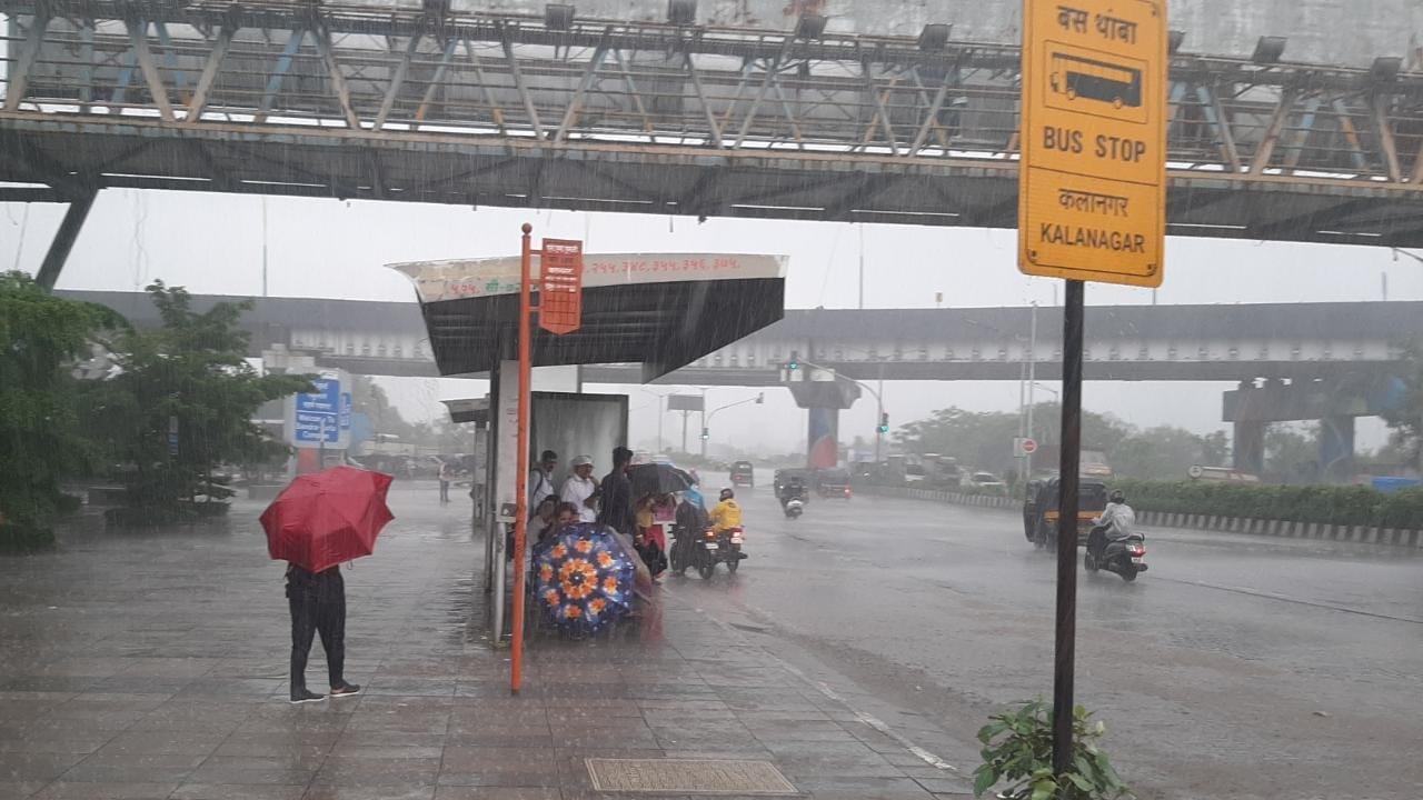 Passengers brave the monsoon as they wait to catch their buses. Pic/Sameer Markande